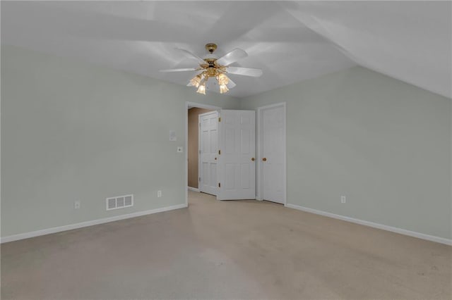 unfurnished bedroom featuring visible vents, baseboards, ceiling fan, light colored carpet, and vaulted ceiling