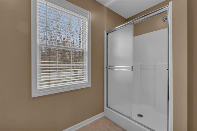 full bath featuring a shower stall and baseboards