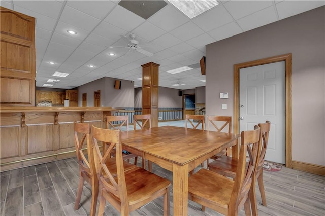 dining area featuring a paneled ceiling, light wood-style floors, and ceiling fan