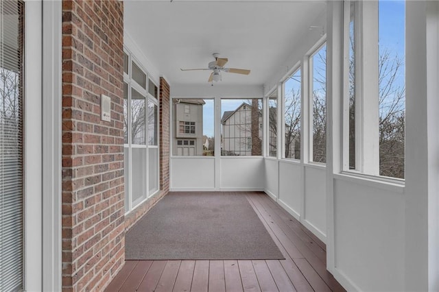 unfurnished sunroom with ceiling fan