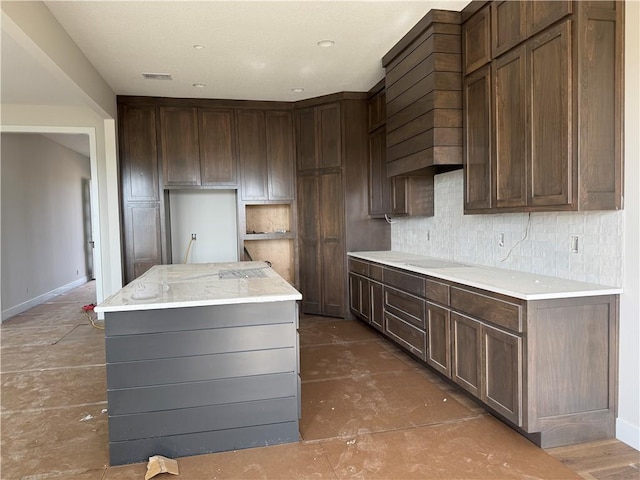 kitchen with visible vents, baseboards, backsplash, white electric cooktop, and a center island