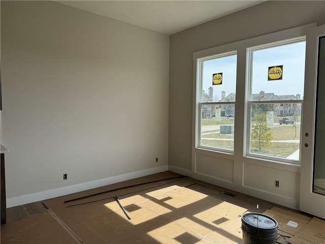 empty room featuring visible vents, baseboards, and wood finished floors