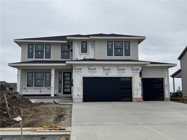 view of front of house featuring a garage, driveway, and stucco siding