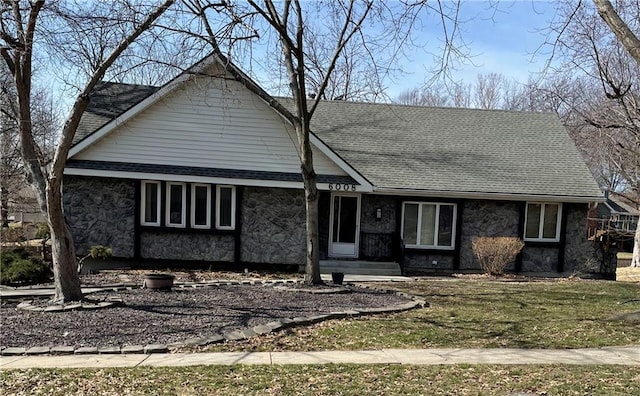 view of front of property with stone siding and roof with shingles