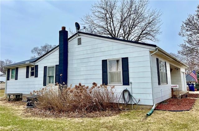 back of property with a chimney and a lawn