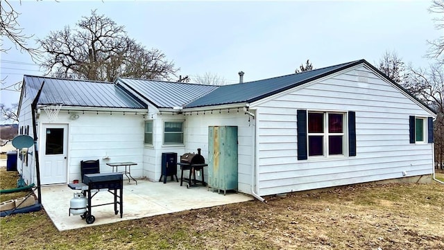 rear view of property featuring metal roof and a patio