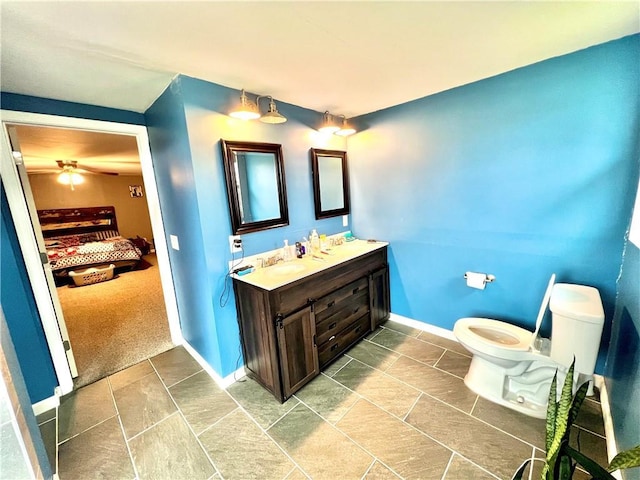 bathroom featuring vanity, toilet, and baseboards