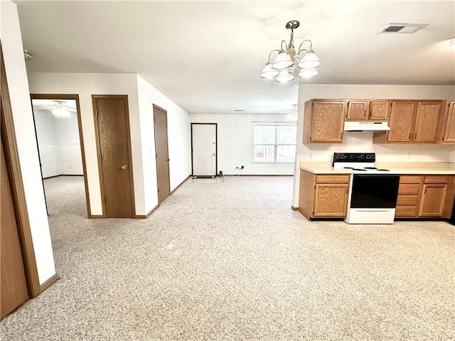 kitchen featuring electric range, visible vents, light countertops, under cabinet range hood, and pendant lighting