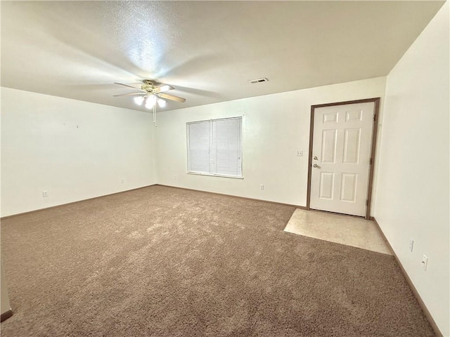 unfurnished room with a ceiling fan, visible vents, and carpet flooring