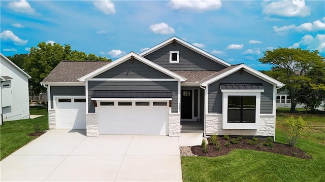 craftsman-style house with a front lawn, roof with shingles, a garage, stone siding, and driveway