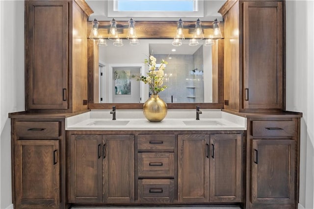 bathroom featuring double vanity, walk in shower, and a sink