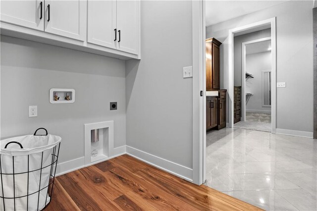 washroom featuring hookup for a washing machine, cabinet space, baseboards, and electric dryer hookup