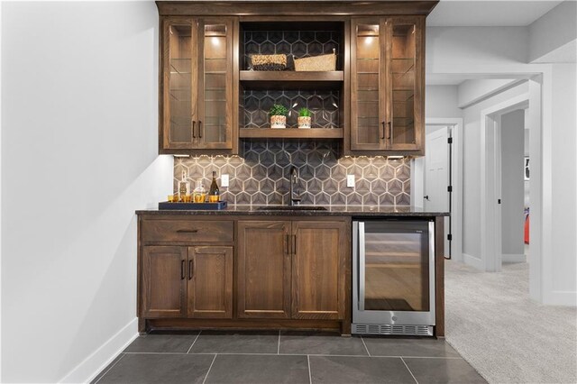 bar featuring beverage cooler, a sink, dark carpet, indoor wet bar, and decorative backsplash