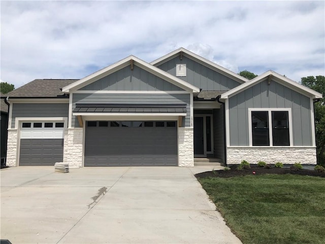 craftsman inspired home featuring board and batten siding, a garage, stone siding, and driveway