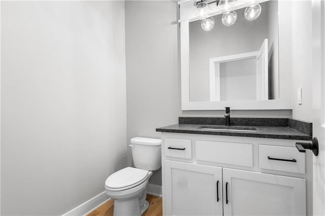 17147 S Heatherwood St, Olathe, KS 66062 - bathroom with toilet, vanity, baseboards, and wood finished floors