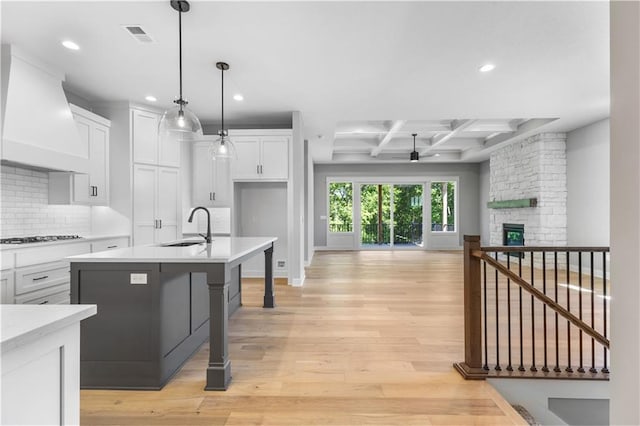 17147 S Heatherwood St, Olathe, KS 66062 - kitchen featuring wall chimney exhaust hood, a sink, open floor plan, light countertops, and ceiling fan
