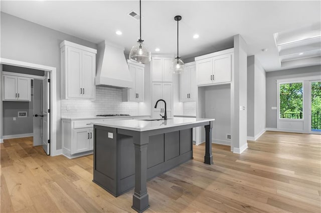 17147 S Heatherwood St, Olathe, KS 66062 - kitchen with wall chimney exhaust hood, a sink, baseboards, backsplash, and white cabinets