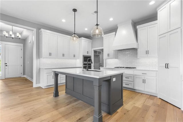 17147 S Heatherwood St, Olathe, KS 66062 - kitchen featuring custom range hood, a sink, light countertops, decorative backsplash, and white cabinets