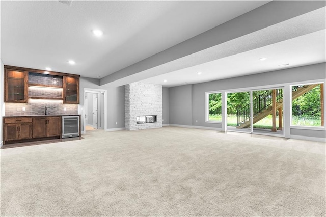 17147 S Heatherwood St, Olathe, KS 66062 - unfurnished living room featuring wine cooler, wet bar, light colored carpet, recessed lighting, and baseboards