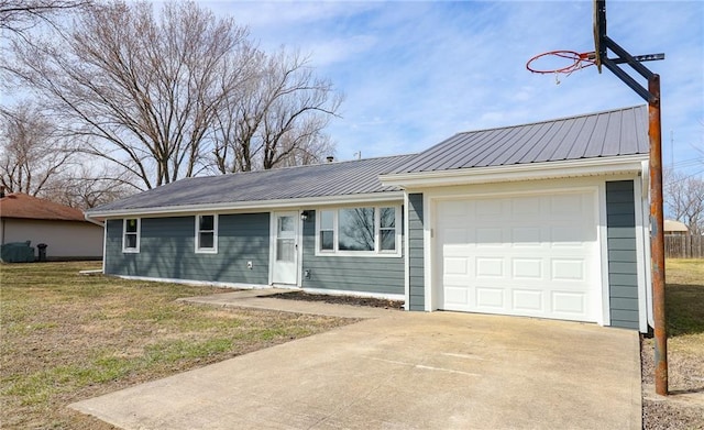 ranch-style home featuring a front yard, metal roof, driveway, and an attached garage