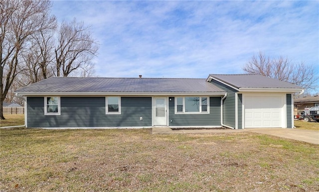 ranch-style home featuring a garage, a front yard, concrete driveway, and metal roof