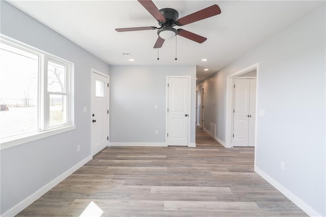 spare room with light wood finished floors, visible vents, baseboards, and recessed lighting