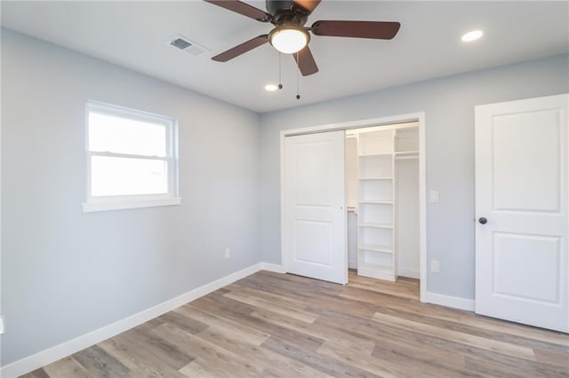 unfurnished bedroom with light wood finished floors, baseboards, visible vents, and a closet