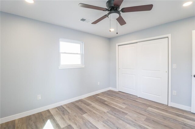 unfurnished bedroom with visible vents, light wood-style flooring, and baseboards