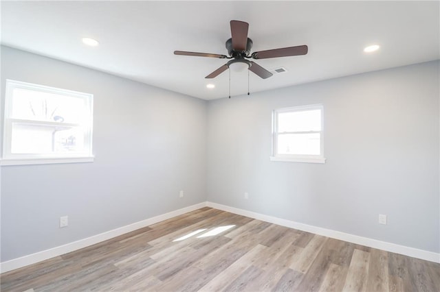 spare room with light wood-type flooring, baseboards, and recessed lighting