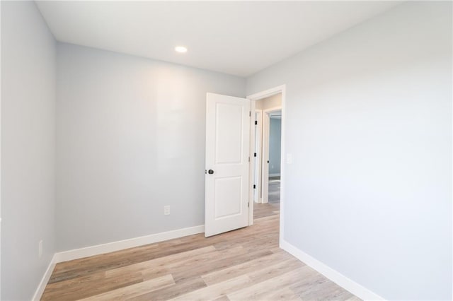 unfurnished room featuring light wood-type flooring, baseboards, and recessed lighting