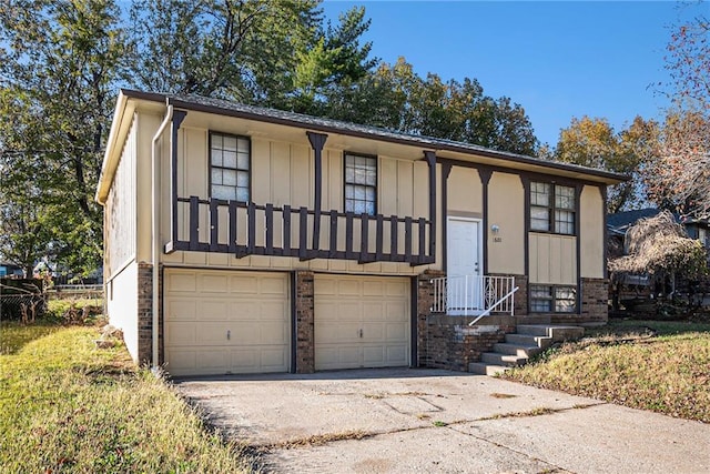 bi-level home featuring brick siding, board and batten siding, concrete driveway, and a garage