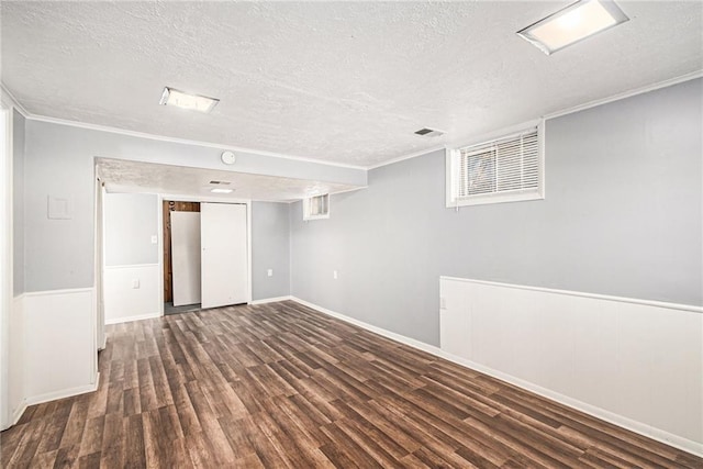 finished basement with visible vents, a textured ceiling, and wood finished floors