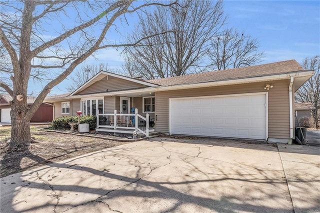 ranch-style house featuring covered porch, driveway, and an attached garage