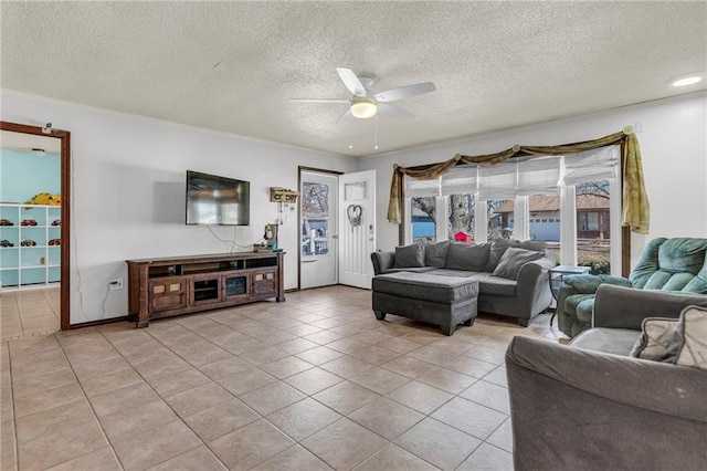 living area with light tile patterned floors, ceiling fan, and a textured ceiling