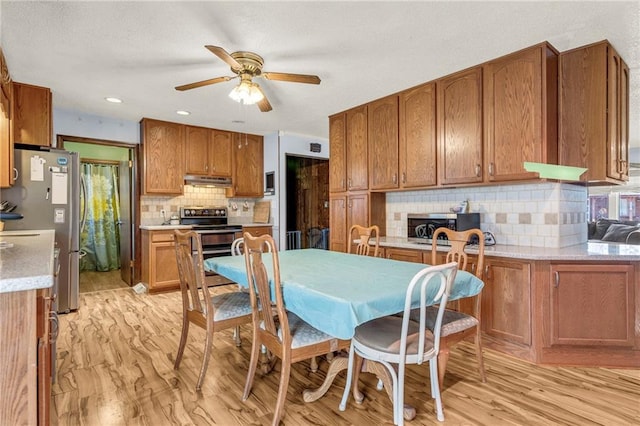 kitchen featuring stainless steel appliances, under cabinet range hood, and brown cabinets