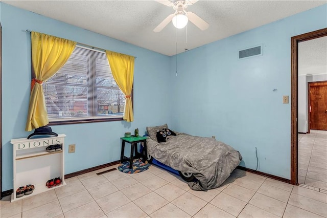 bedroom featuring a textured ceiling, baseboards, visible vents, and tile patterned floors