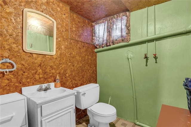 bathroom featuring vanity, toilet, and wallpapered walls