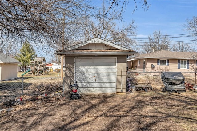 detached garage featuring driveway and fence