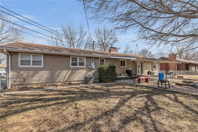 rear view of house featuring central AC unit, a lawn, a chimney, fence, and a patio area