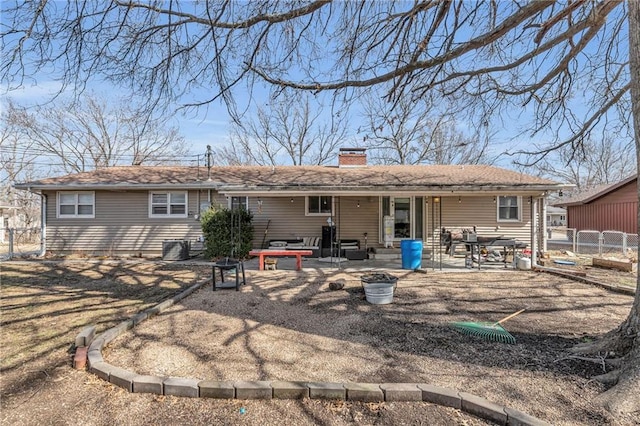 rear view of house featuring a patio, cooling unit, fence, a gate, and a chimney