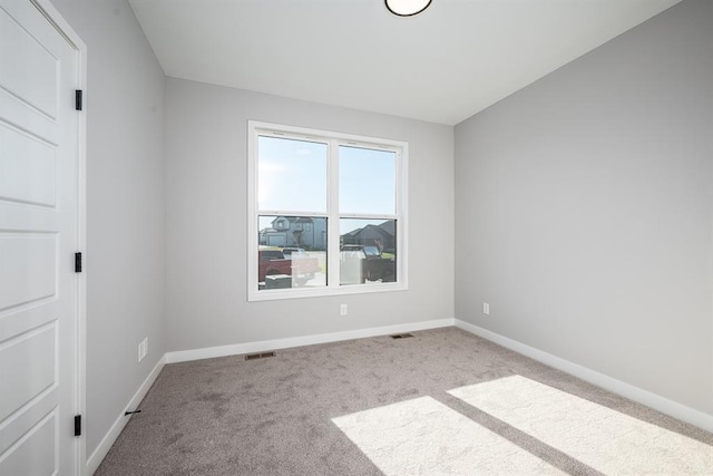 carpeted empty room featuring visible vents and baseboards