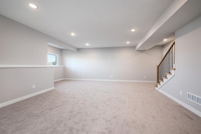 below grade area with recessed lighting, visible vents, baseboards, stairs, and carpet