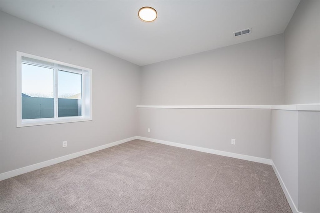 spare room featuring carpet floors, baseboards, and visible vents