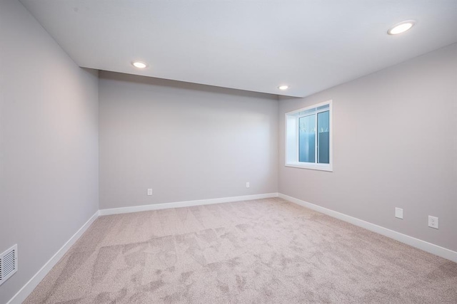 spare room featuring carpet floors, recessed lighting, visible vents, and baseboards