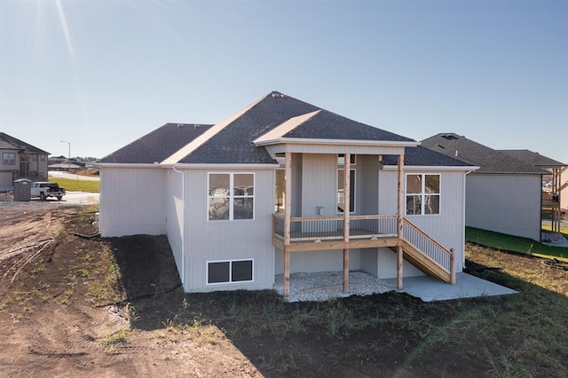 rear view of property with a shingled roof