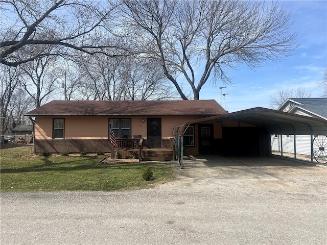 single story home with driveway, an attached carport, and a front yard