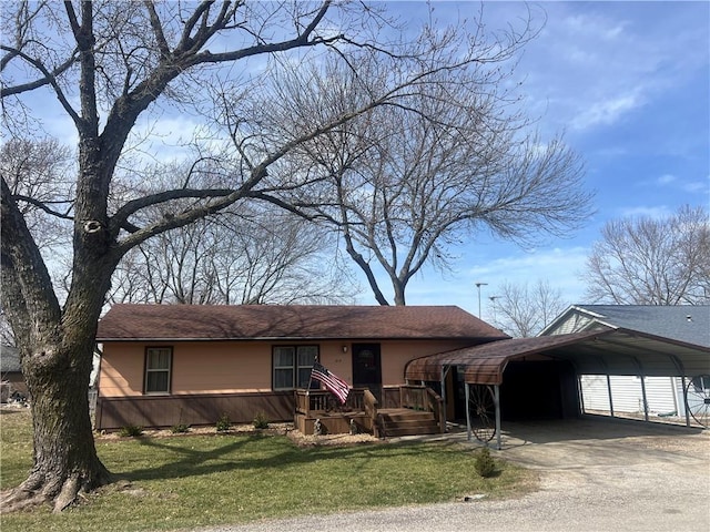 ranch-style house featuring a carport, driveway, and a front yard