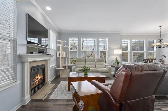 living room with baseboards, a notable chandelier, wood finished floors, and a tiled fireplace