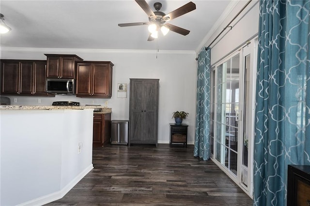 kitchen with dark wood-style floors, ceiling fan, dark brown cabinets, crown molding, and stainless steel microwave