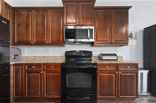 kitchen featuring black appliances and light stone counters